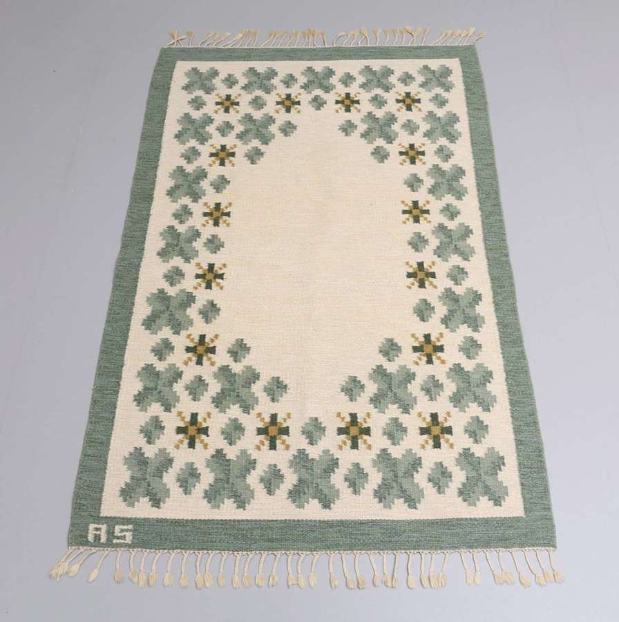 Swedish flat weave rug in soft green tones on cream background